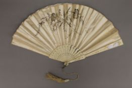 A Victorian bone and silk fan. 32 cm long.
