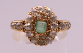 An 18 ct gold, diamond and emerald ring. Ring size O/P. 4.3 grammes total weight.