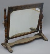 An early 20th century carved oak dressing table mirror. 58 cm wide.