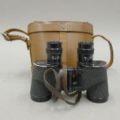 A cased pair of Bausch and Lamb WWII military issue binoculars. The case 19 cm wide.