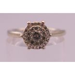 A 9 ct white gold diamond cluster ring. Ring size M. 3.1 grammes total weight.