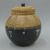 A tribal wooden and woven mother-of-pearl inlaid storage box. 29 cm high.
