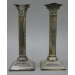 A pair of Corinthian column silver candlesticks. 23 cm high.