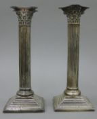 A pair of Corinthian column silver candlesticks. 23 cm high.