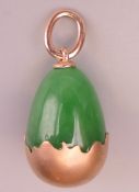 A Russian 14 ct gold jade egg formed pendant. 2 cm high.