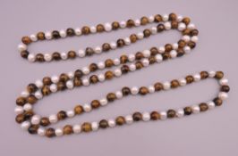 A tiger's eye and pearl necklace. Approximately 122 cm long.