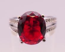 A silver, red stone and cubic zirconia ring. Ring size O/P.