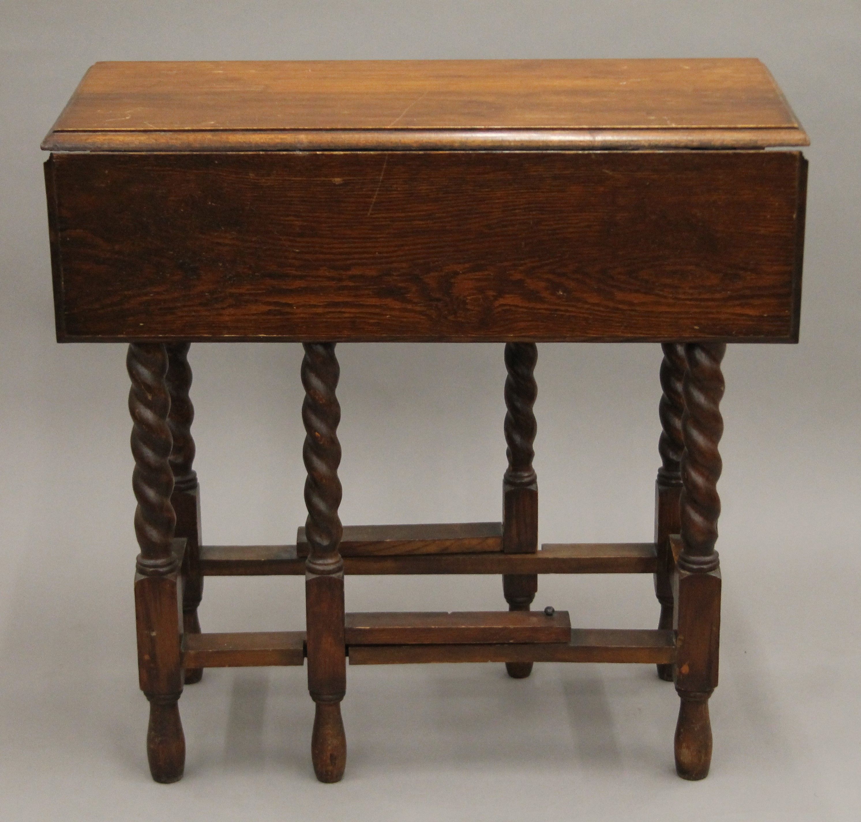 An oak barley twist gate leg drop-leaf table. 76 cm long.