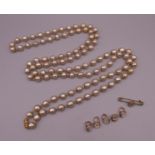 A faux pearl necklace and a quantity of various shirt studs. The necklace 148 cm long.