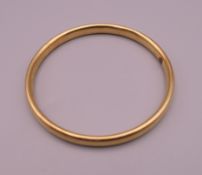 A 15 ct gold bangle (with metal core). 7 cm internal diameter. 13.4 grammes.