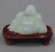 A jade model of Buddha on a wooden stand. 6.5 cm high overall.