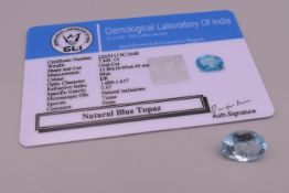 An oval cut natural blue topaz in a Gemological Laboratory of India gem stone report card, 7.
