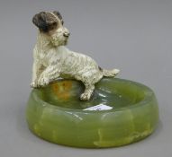An onyx ash tray surmounted with a cold painted model of a terrier. 12 cm high overall.