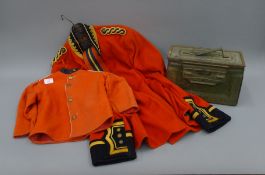 A military dress jacket, a miniature version and an ammunition box.
