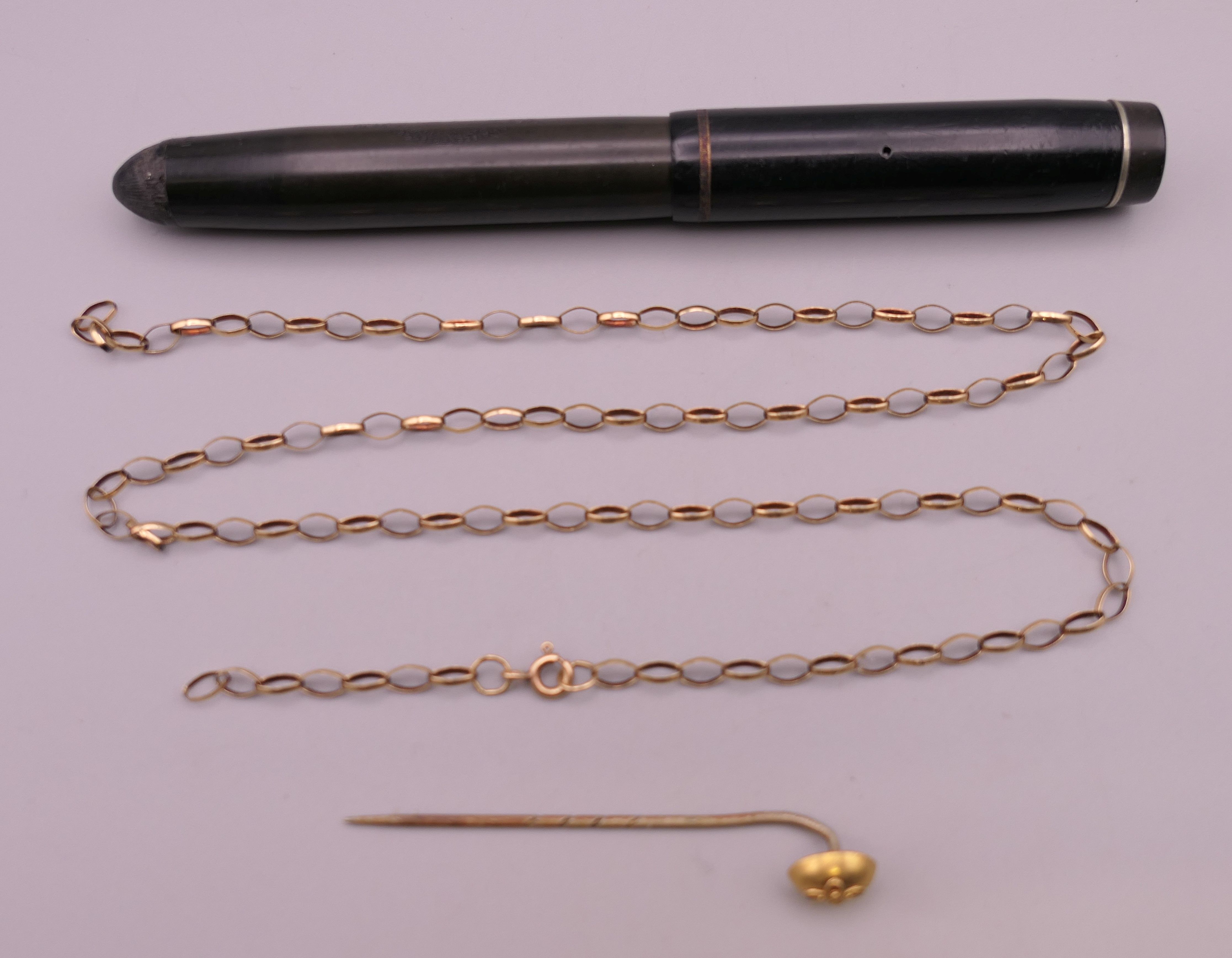 A 9 K gold chain (3.2 grammes), a stick pin and a fountain pen with a 14 K gold nib.