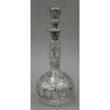 An Art Nouveau decanter with silver overlay. 25 cm high.