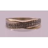 A 9 ct gold diamond set crossover ring. Ring size M. 1.3 grammes total weight.