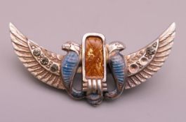 A winged enamel brooch. 4.25 cm wide.