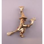 A 9 ct gold articulated witch on a broomstick form pendant. Approximately 4 cm high. 7.