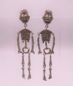 A pair of diamond skeleton earrings. 5.5 cm high.