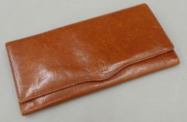 An Omega leather wallet. 20.5 cm wide.