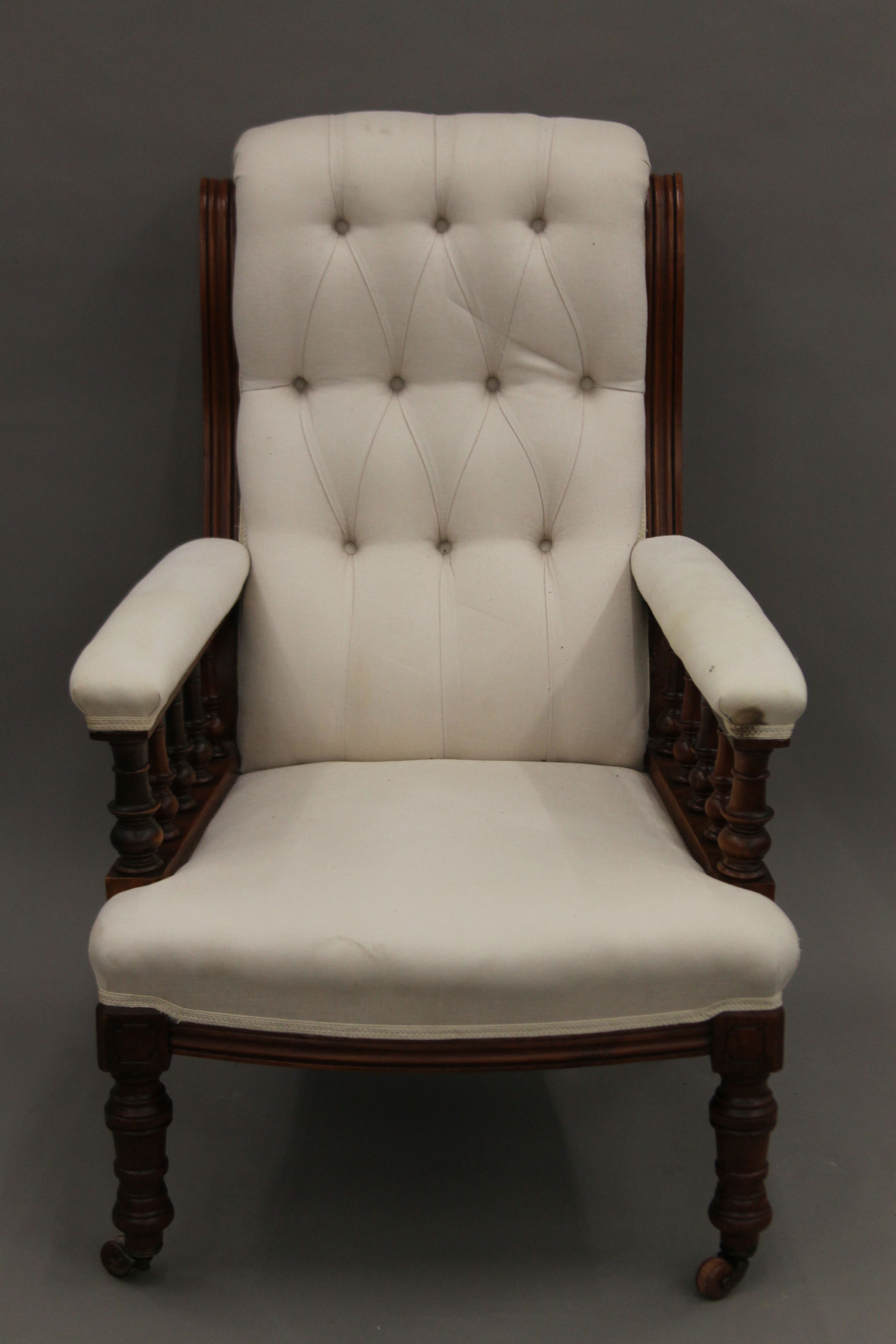 A Victorian upholstered button back walnut open armchair. 69 cm wide.