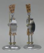 A pair of mixed metal figural candle holders. 25 cm high.
