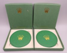 A pair of Rolex Geneve coasters, boxed. 10 cm diameter.