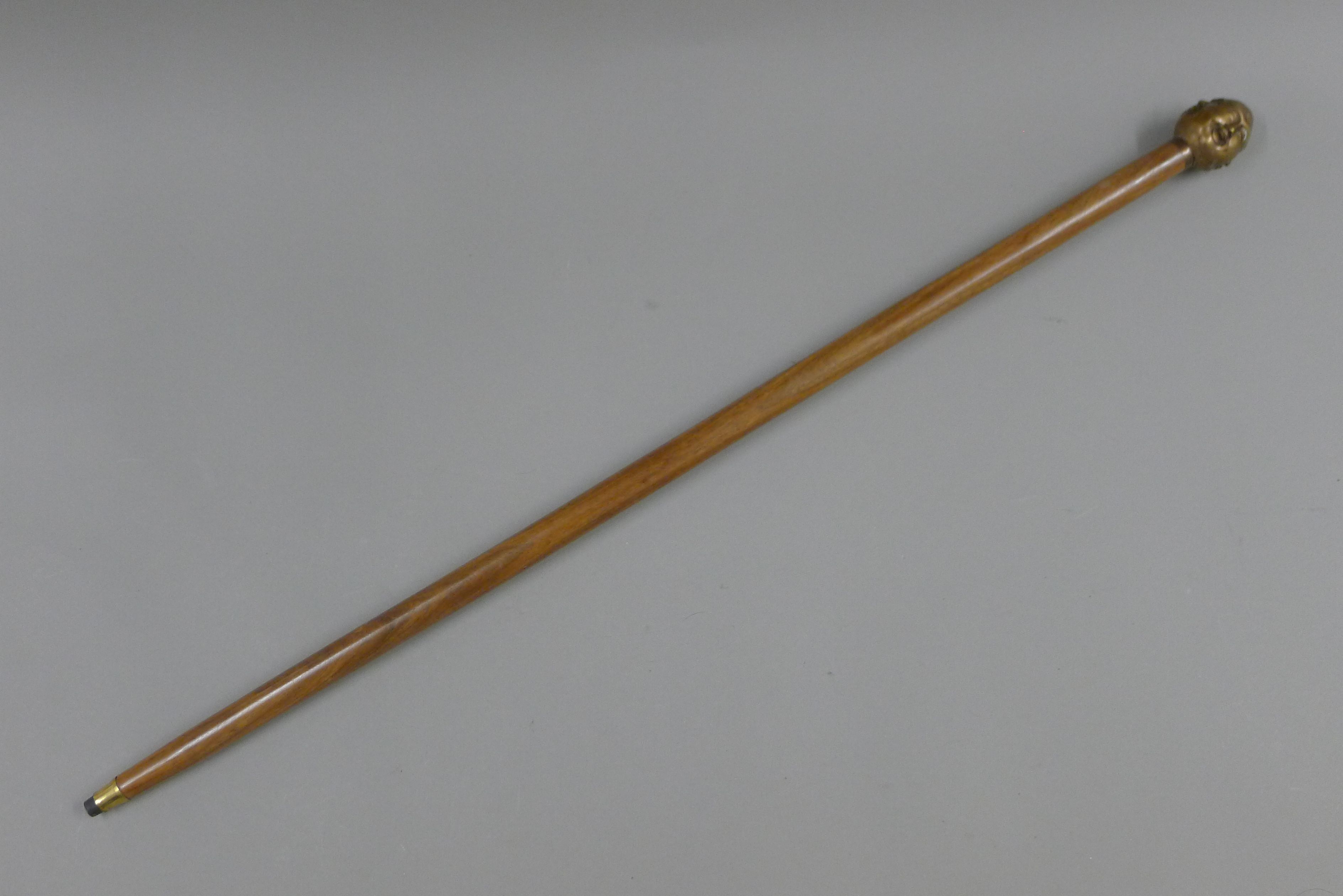 A walking stick with four-faced Buddha handle. 92 cm long.