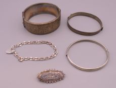 Three silver bangles, a silver bracelet and a silver brooch. Brooch 4 cm long.