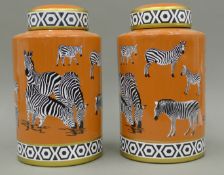 A pair of orange ground pottery ginger jars decorated with zebras. 29 cm high.