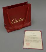 A Cartier Bag with certificate, stamped and numbered, in a Cartier leather folding wallet.