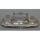 A Victorian silver plated desk stand, with associated inkwells. 32.5 cm long.