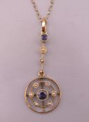 An Edwardian 9 ct gold sapphire and seed pearl circular pendant on a 9 ct gold chain. Pendant 3.