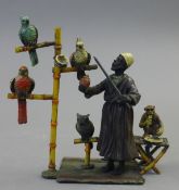 A cold painted bronze model of a parrot seller. 15.5 cm high.