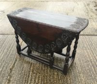 A Georgian carved oak drop leaf table. 106 cm long.