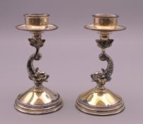 A pair of dolphin form sterling silver candlesticks. 9.5 cm high.
