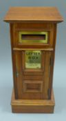 A wooden square post box. 50 cm high.