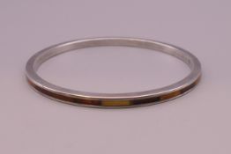 A silver and amber bangle. 7.5 cm inner diameter.