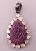A carved ruby and diamond set pendant. 3.5 cm high excluding suspension loop.
