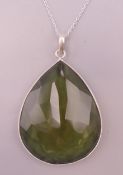 A silver mounted green stone pendant on a silver chain. Pendant 4.5 cm high, chain 44 cm long.