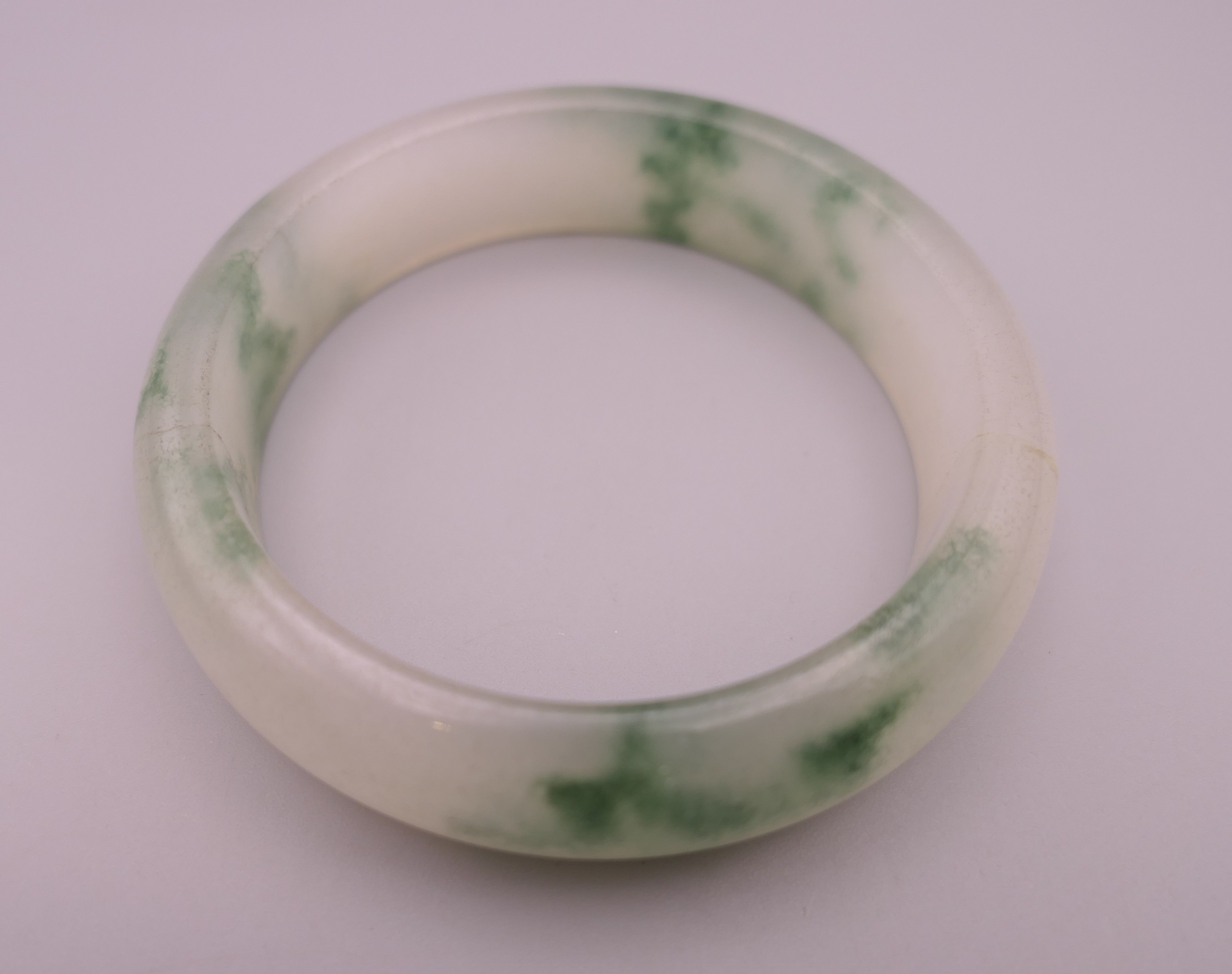 A jade bangle. Internal diameter 5.75 cm.