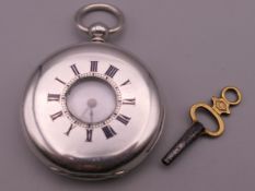 An antique silver pocket watch, the case stamped 'Fine Silver', with key.