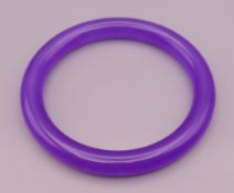 A lilac jade bangle. 6 cm internal diameter.