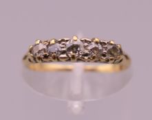 An 18 ct gold five stone diamond ring. Ring size I/J. 1.9 grammes total weight.