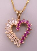 A 10 K gold, ruby and white stone heart shaped pendant on a 9 ct gold chain. Pendant 2.