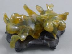 A Chinese hardstone model of a goldfish on a wooden base. 8.5 cm long.