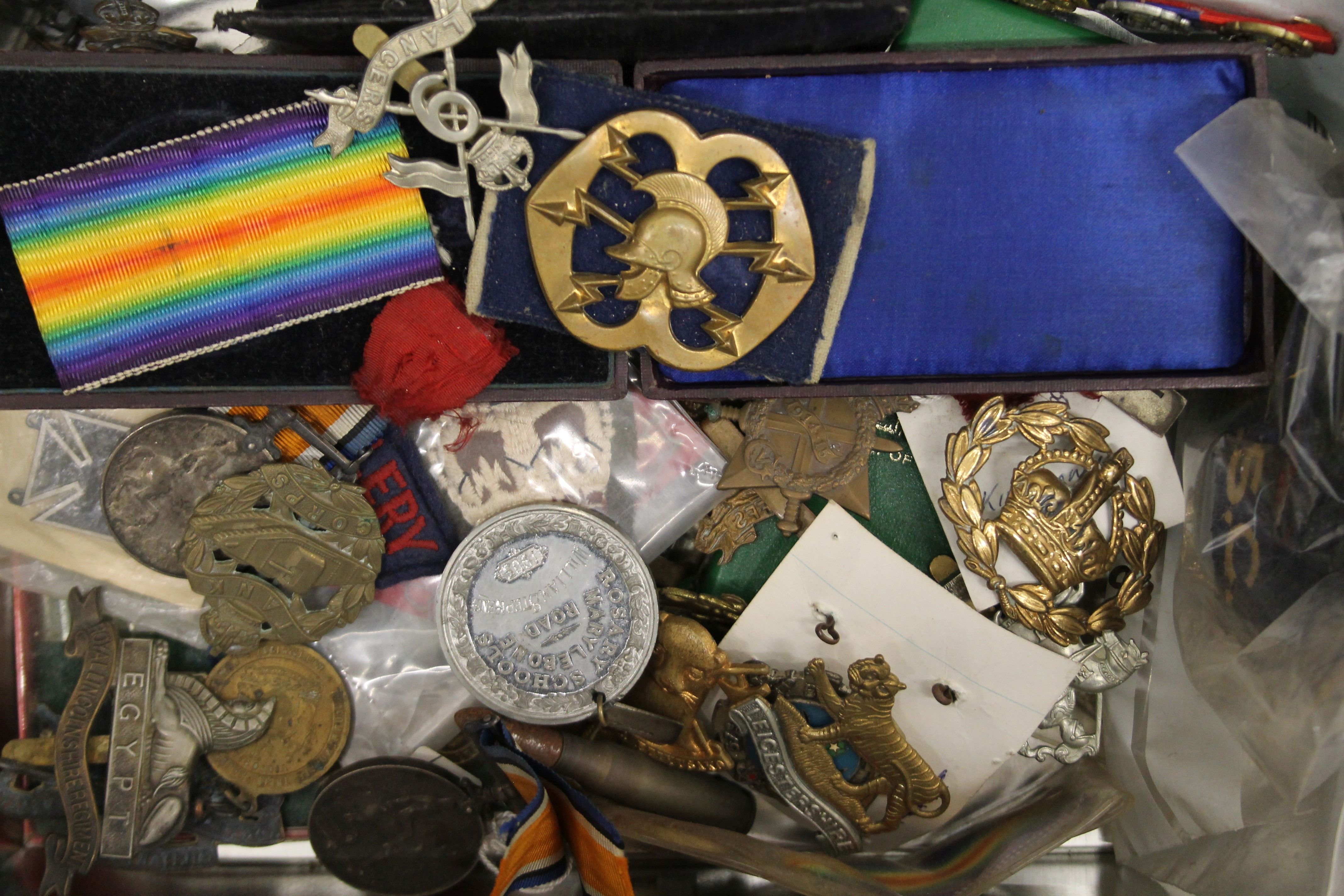 A quantity of various military medals, cap badges, etc.