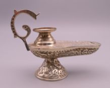 A silver, possibly Egyptian, oil lamp form table lighter. 10 cm long.