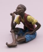 A bronze figure of a seated African man smoking a pipe. 6 cm high.